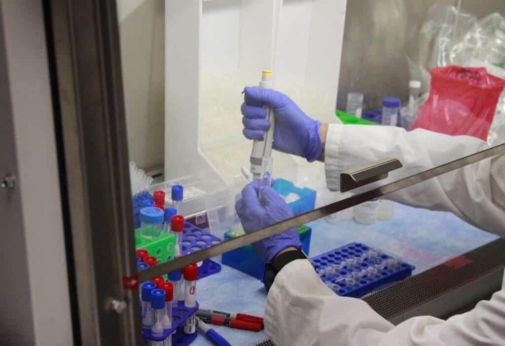 Lab tech handling DNA sample in lab