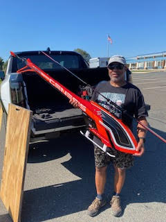 Ron proudly holds up a large, red remote control helicopter.